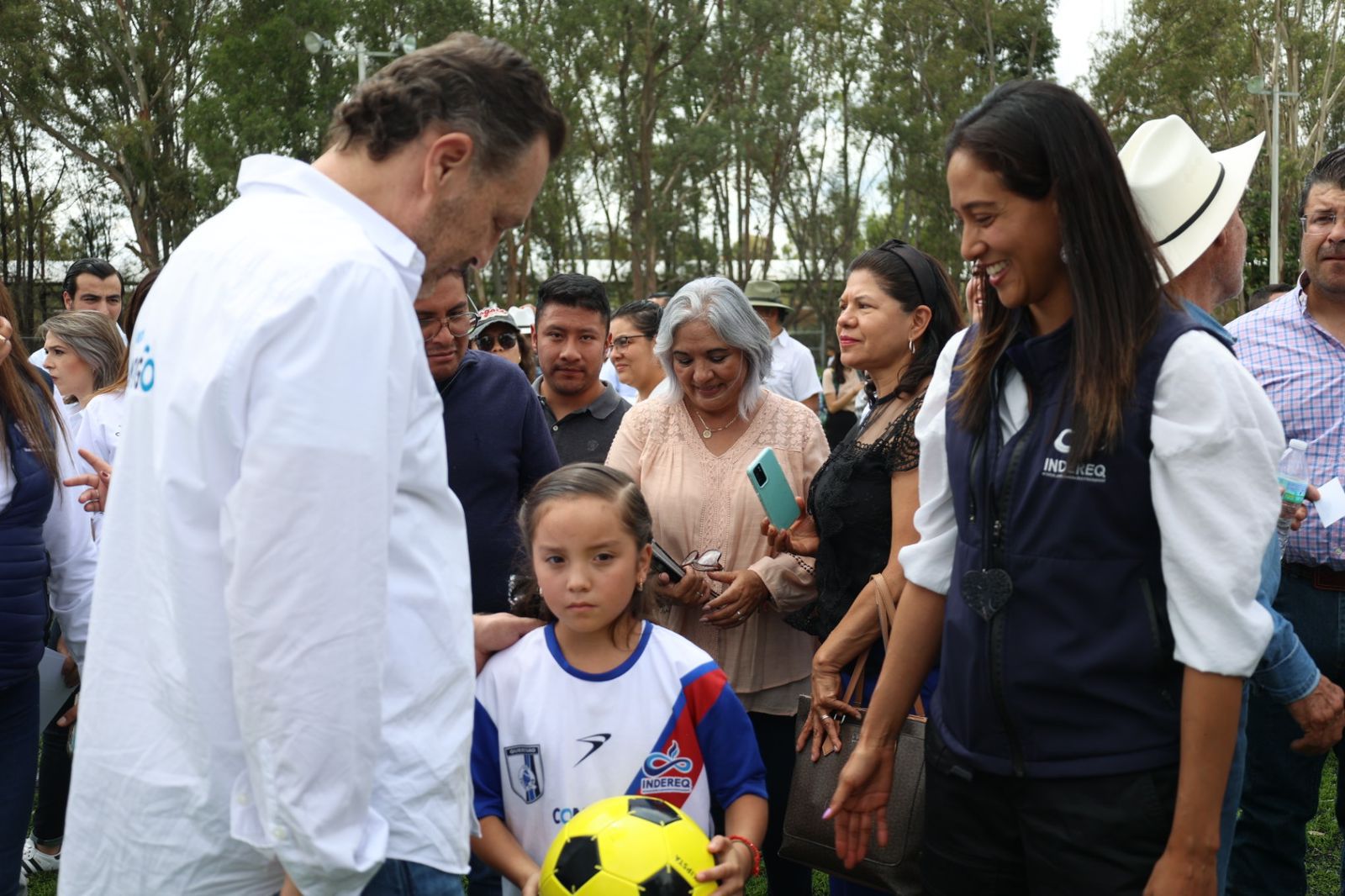 Niña con balón, saludando al Gober y a la Directora de Indereq
